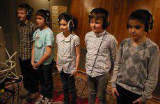 Des enfants enregistrant leur chanson dans un studio d'enregistrement